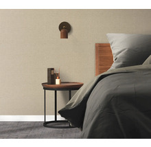 Spálňa s posteľou, nočným stolíkom, nástennou lampou a textilnou tapetou