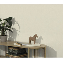 Obývacia izba so štruktúrovanou tapetou, zdobená rastlinou, figúrkou koňa a knihami na stole