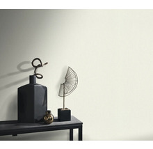 Dekoratívne vázy a sochy na stole pred stenou