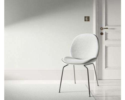 Scéna so stoličkou s kovovými nohami a čalúneným sedadlom vo svetlej miestnosti.