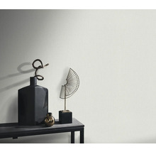 Detail štruktúrovanej steny s dekoratívnymi predmetmi na polici.