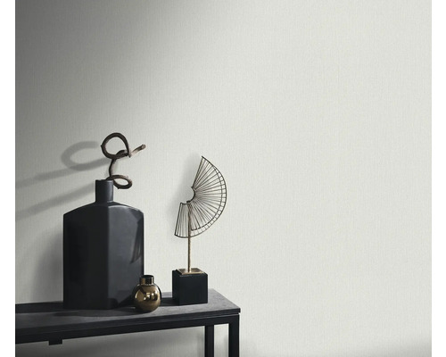 Detail štruktúrovanej steny s dekoratívnymi predmetmi na polici.