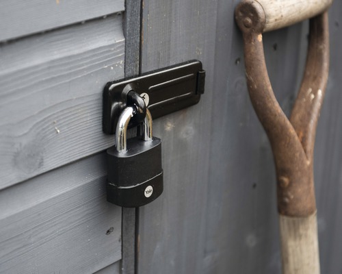 Visiaci zámok na dverách záhradného domčeka s rýľom
