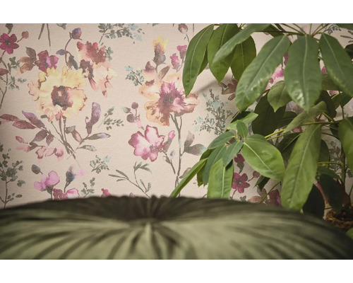 Dekoratívna tapeta s kvetinovým vzorom a izbová rastlina v popredí.