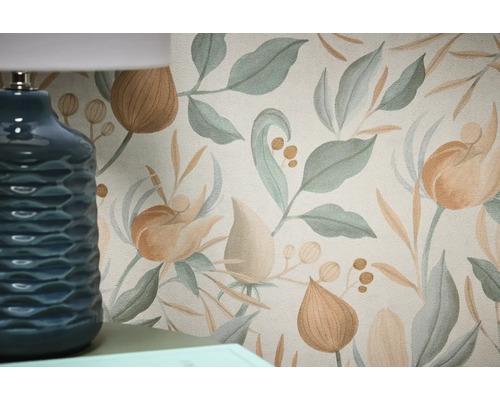 Detailný záber kvetinovej tapety s listami a kvetmi vedľa modrej lampy