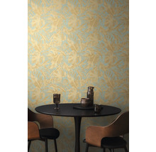 Scéna so stolom, stoličkami a stenou s tapetou s listovým vzorom.