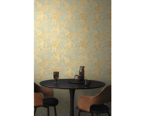 Scéna so stolom, stoličkami a stenou s tapetou s listovým vzorom.