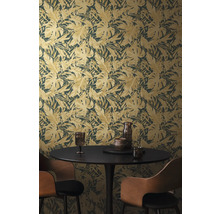 Izba s tapetou s motívom listov, jedálenským stolom a stoličkami.