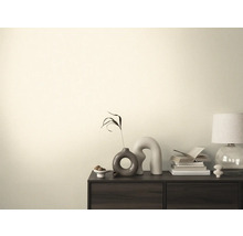 Obývacia izba s komodou, stolnou lampou, knihami a dekoráciami.