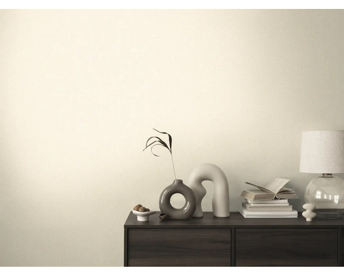 Obývacia izba s komodou, stolnou lampou, knihami a dekoráciami.