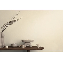 Dekoratívne aranžmán s vázou, vetvami, misou a keramickými objektmi na stole.