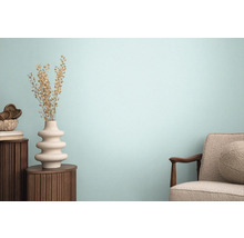 Obývacia izba s kreslom, dreveným stolom a ozdobnou vázou