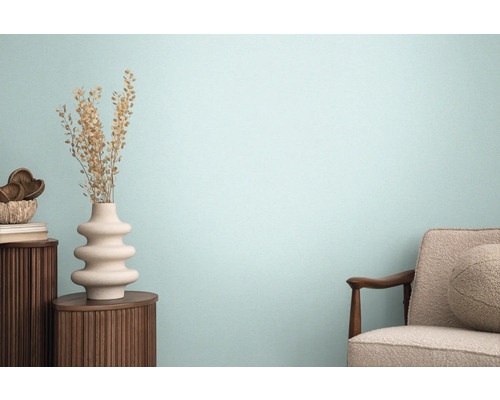 Obývacia izba s kreslom, dreveným stolom a ozdobnou vázou