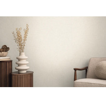 Svetlá miestnosť so štruktúrovanými tapetami, zdobená vázou a kreslom pre útulnú atmosféru.