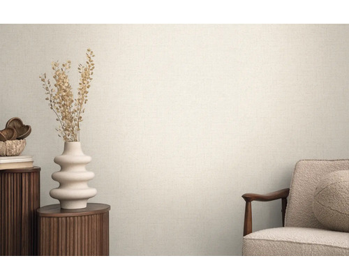 Svetlá miestnosť so štruktúrovanými tapetami, zdobená vázou a kreslom pre útulnú atmosféru.