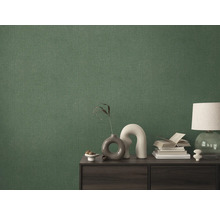 Detailný záber zelenej textilnej tapety na stene za skriňou.