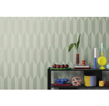 Interiér s geometrickou tapetou a policou s dekoratívnymi predmetmi