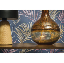 Dekoratívna scéna s lampou, vázou a vzorovanou tapetou.