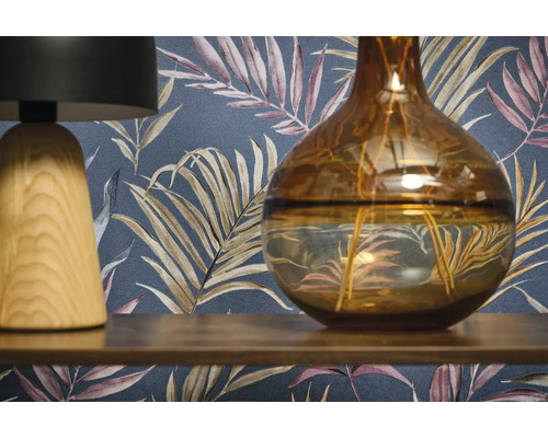 Dekoratívna scéna s lampou, vázou a vzorovanou tapetou.