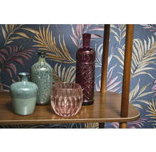 Dekoratívne vázy a sklenené predmety na drevenej polici pred vzorovanou tapetou