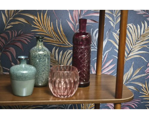 Dekoratívne vázy a sklenené predmety na drevenej polici pred vzorovanou tapetou
