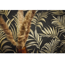 Detail čiernej tapety so zlatým vzorom palmových listov