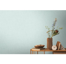 Obývacia izba s drevenou policou, kvetinovou vázou a dekoráciami pred stenou