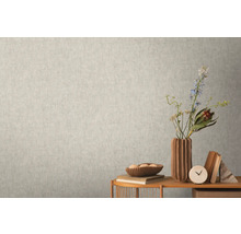 Detail svetlej steny s jemnou vzorovanou tapetou vytvárajúcou pokojnú a jednotnú textúru.