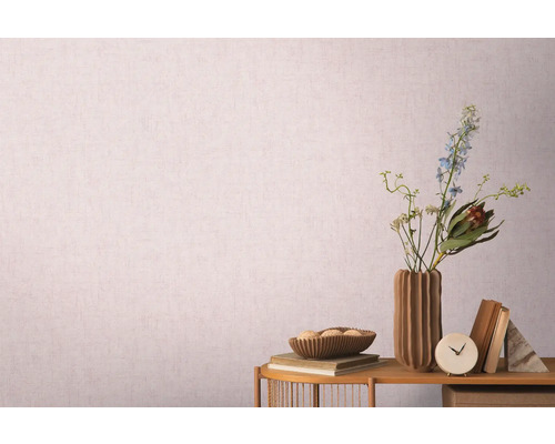 Dekoratívne zátišie s vázou, kvetmi a knihami pred vzorovanou tapetou