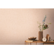 Dekoratívna scéna s vázou, kvetmi, knihami a doplnkami na stole pred stenou