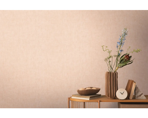 Dekoratívna scéna s vázou, kvetmi, knihami a doplnkami na stole pred stenou