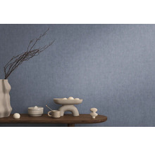 Dekoratívny interiér s modrou tapetou, stôl s dekoráciami ako váza, misa a keramické figúrky