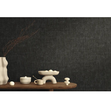 Štýlový dizajn izby s tmavou vliesovou tapetou a dekoratívnymi prvkami na drevenom stole.