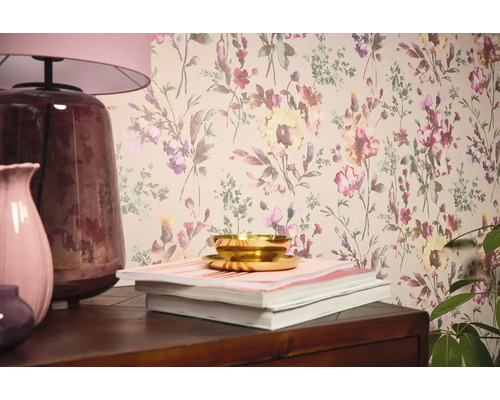 Interiérová scéna s kvetinovou tapetou, stolnou lampou, vázami, knihami a miskou.