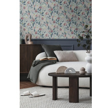 Obývacia izba s kvetinovou tapetou, pohovkou, stolom a dekoráciami pre útulnú atmosféru.