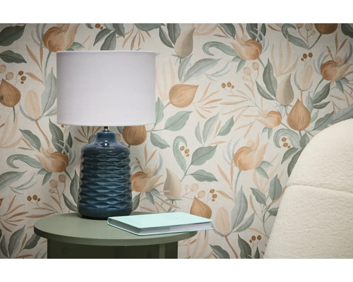 Scéna s tapetou s kvetinovým vzorom, stolnou lampou a knihou na príručnom stolíku