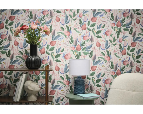 Obývacia izba s kvetinovou tapetou, regálom a lampou pre štýlovú atmosféru.