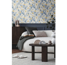 Obývacia izba s kvetinovou tapetou, pohovkou, konferenčným stolíkom a dekoratívnymi doplnkami pre útulnú atmosféru.