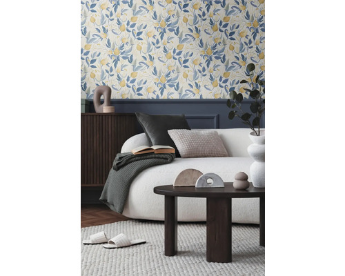 Obývacia izba s kvetinovou tapetou, pohovkou, konferenčným stolíkom a dekoratívnymi doplnkami pre útulnú atmosféru.