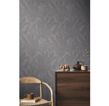 Pohľad na miestnosť so vzorovanou tapetou a dekoratívnymi prvkami na drevenej skrini.