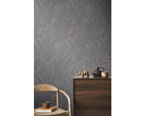 Pohľad na miestnosť so vzorovanou tapetou a dekoratívnymi prvkami na drevenej skrini.