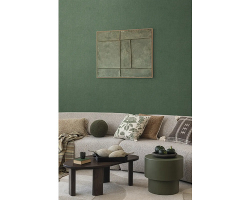 Obývacia izba s pohovkou, vankúšmi, konferenčným stolíkom a nástennou dekoráciou pre útulnú atmosféru