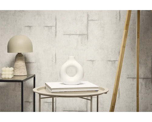 Dekoratívne interiérové vybavenie s tapetou v betónovom vzhľade, stolnou lampou a vázou