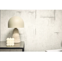 Dekoratívna stolná lampa s travertínovou základňou vedľa bublinkovej sviečky na stole