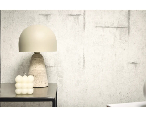 Dekoratívna stolná lampa s travertínovou základňou vedľa bublinkovej sviečky na stole