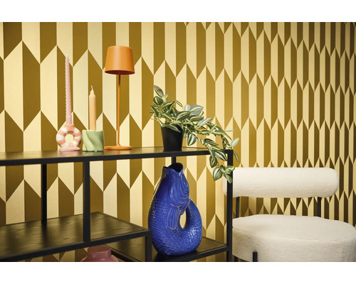 Dekoratívna izba s regálom, lampou, sviečkami, rastlinou, vázou a stoličkou pred vzorovanou tapetou