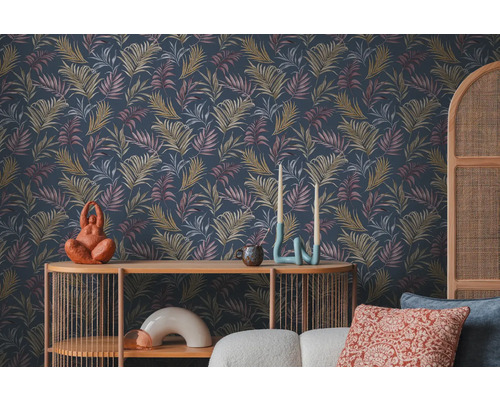 Scéna s tmavou tapetou so vzorom listov, stôl a dekoratívne predmety