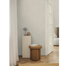 Svetlá miestnosť so vzorovanou tapetou, stoličkou a dekoráciami pre štýlový interiér.