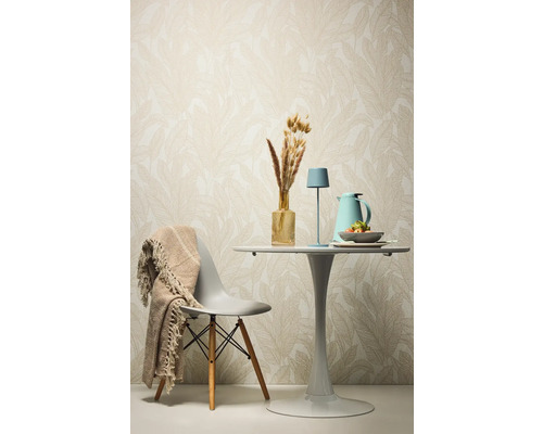 Dekoratívny jedálenský stôl so stoličkou, stolnou lampou a doplnkami pred vzorovanou tapetou