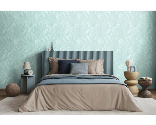 Spálňa s posteľou, nočnými stolíkmi a tapetou s motívom listov pre relaxačnú atmosféru.